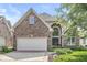 Charming brick home boasts a two-car garage, arched entryway, and meticulously maintained landscaping at 11244 Blackwalnut Pt, Indianapolis, IN 46236