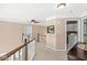 Second floor hallway with wooden railing, a ceiling fan, and laundry room access at 11244 Blackwalnut Pt, Indianapolis, IN 46236
