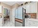 Bright kitchen featuring stainless steel refrigerator, white cabinets, and marble flooring at 11244 Blackwalnut Pt, Indianapolis, IN 46236