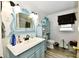 Bathroom featuring a blue vanity with modern fixtures, and a charming decorative mirror at 121 Mulberry Dr, Chesterfield, IN 46017