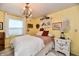 Bright bedroom features a bed with soft linens, charming decor, and a chandelier at 121 Mulberry Dr, Chesterfield, IN 46017