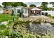Lush backyard with a serene pond, patio and a charming garden at 121 Mulberry Dr, Chesterfield, IN 46017