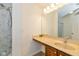 Bathroom featuring wood vanity, tan countertops, and shower with curtain rod at 12772 Tram Ln, Carmel, IN 46032