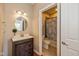 Bathroom featuring a wood vanity, round mirror, and a shower/tub with a patterned curtain at 12772 Tram Ln, Carmel, IN 46032
