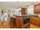 Kitchen island with seating, granite countertops, a stainless microwave, and natural light from the window at 12772 Tram Ln, Carmel, IN 46032