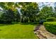 Lush green backyard with mature trees and landscaping creating a serene and private outdoor space at 14149 Ledgewood Way, Carmel, IN 46032