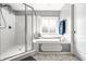 Clean bathroom with white tile shower, soaking tub, and natural light from the window at 14149 Ledgewood Way, Carmel, IN 46032