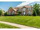 Charming brick house featuring a well-maintained lawn, professional landscaping, and inviting curb appeal at 14149 Ledgewood Way, Carmel, IN 46032