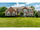 Beautiful brick home with manicured lawn and lush landscaping on a sunny day at 14149 Ledgewood Way, Carmel, IN 46032
