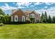 Stunning two-story brick home with a lush green lawn and mature trees at 14149 Ledgewood Way, Carmel, IN 46032