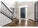 Elegant foyer with dark wood floors, paneled walls, and staircase with black wrought iron railing at 14149 Ledgewood Way, Carmel, IN 46032