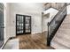 Grand foyer featuring hardwood floors, staircase with carpeted treads, and glass paneled doors at 14149 Ledgewood Way, Carmel, IN 46032