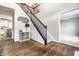 Inviting foyer boasting hardwood floors, staircase with dark wood railing, and designer accents at 14149 Ledgewood Way, Carmel, IN 46032