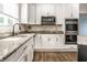 Close up on the kitchen with stainless steel microwave and ovens built into white cabinets and granite countertops at 14149 Ledgewood Way, Carmel, IN 46032