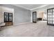 Spacious living room features neutral carpet, gray walls, modern black doors, and opens to a large adjacent space at 14149 Ledgewood Way, Carmel, IN 46032