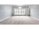 Empty room features light gray walls, neutral carpet, white trim and shuttered window at 14149 Ledgewood Way, Carmel, IN 46032