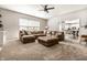 Open living room featuring a plush sectional sofa, fan, and sliding glass door at 14149 Ledgewood Way, Carmel, IN 46032