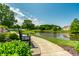Scenic pond view with bench, lush landscaping, and walking path offering a tranquil outdoor experience at 14149 Ledgewood Way, Carmel, IN 46032