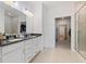 Bright bathroom with double vanity, tiled floors, shower, and view into walk-in closet at 14848 Stonneger St, Westfield, IN 46074