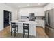 Eat-in kitchen featuring white cabinets, quartz countertops, stainless appliances, and view to exercise room at 14848 Stonneger St, Westfield, IN 46074