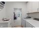 Bright laundry room with modern washer and dryer, sink, white cabinets, and easy access to other rooms at 14848 Stonneger St, Westfield, IN 46074