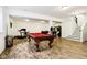 A basement includes a pool table, seating, an arcade game, and stairs to the upper level at 1521 Avondale Dr, Westfield, IN 46074