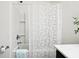 Bright bathroom featuring a white bathtub, shower with leaf-patterned curtain, and chrome fixtures at 1521 Avondale Dr, Westfield, IN 46074