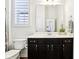 This bathroom features a toilet, large mirror over vanity, and plantation shutters over the window at 1521 Avondale Dr, Westfield, IN 46074