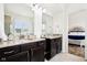 Bright bathroom featuring granite countertop vanities, a large mirror, and a glimpse into the bedroom at 1521 Avondale Dr, Westfield, IN 46074