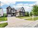 Beautiful brick home with a well-manicured lawn and three-car garage on a sunny day at 1521 Avondale Dr, Westfield, IN 46074