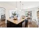 Kitchen island with granite countertop, stainless steel appliances, and view into living and dining areas at 1521 Avondale Dr, Westfield, IN 46074