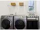 Laundry room with side-by-side washer and dryer and a shelf with organizing baskets at 1521 Avondale Dr, Westfield, IN 46074