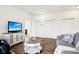 Cozy living room with gray couch, television on accent table, and dark wood floors at 1521 Avondale Dr, Westfield, IN 46074