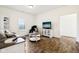 This living room features wood floors, a grey sofa, and a television over an accent cabinet at 1521 Avondale Dr, Westfield, IN 46074