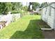 Lawn with trees and white fence near a detached garage at 1641 Winton Ave, Speedway, IN 46224