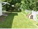 A spacious backyard with grass and partial shade from trees and a white fence at 1641 Winton Ave, Speedway, IN 46224