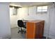 A bright basement featuring a desk, office chair, and cabinet at 1641 Winton Ave, Speedway, IN 46224