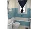 Bathroom with a blue tile, bathtub and shower combination, toilet and window at 1641 Winton Ave, Speedway, IN 46224