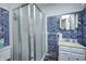 Tiled bathroom with glass shower, vanity, and sink, all in shades of white and blue at 1641 Winton Ave, Speedway, IN 46224