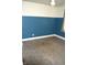 A clean bedroom featuring neutral color scheme with blue accent wall and concrete flooring at 1641 Winton Ave, Speedway, IN 46224