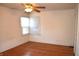 Bright bedroom with hardwood floors, a ceiling fan, and natural light streaming through the corner window at 1641 Winton Ave, Speedway, IN 46224