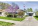 Charming home featuring a well-maintained lawn, blooming trees, and a driveway at 1641 Winton Ave, Speedway, IN 46224