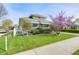 Charming single-Gathering home featuring a well-manicured lawn, sidewalk, and mature landscaping on a sunny day at 1641 Winton Ave, Speedway, IN 46224