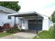 Garage and carport featuring a covered parking space and tidy landscaping at 1641 Winton Ave, Speedway, IN 46224