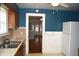 Cozy kitchen featuring an open doorway, blue accent wall, and white appliances at 1641 Winton Ave, Speedway, IN 46224