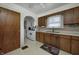 Kitchen with wooden cabinets, white appliances, and linoleum flooring at 1641 Winton Ave, Speedway, IN 46224