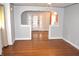 Open-concept living room with hardwood floors, a ceiling fan, and an arched doorway leading to another room at 1641 Winton Ave, Speedway, IN 46224