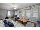 Comfortable living room with a plaid sofa, ceiling fan, and a cozy sitting area bathed in soft, natural light at 1641 Winton Ave, Speedway, IN 46224