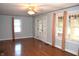 Spacious living room with polished hardwood floors, complemented by light grey walls, ceiling fan, and multiple windows at 1641 Winton Ave, Speedway, IN 46224