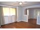 Well-lit living room featuring hardwood floors, light walls, a ceiling fan, and ample natural light from large windows at 1641 Winton Ave, Speedway, IN 46224